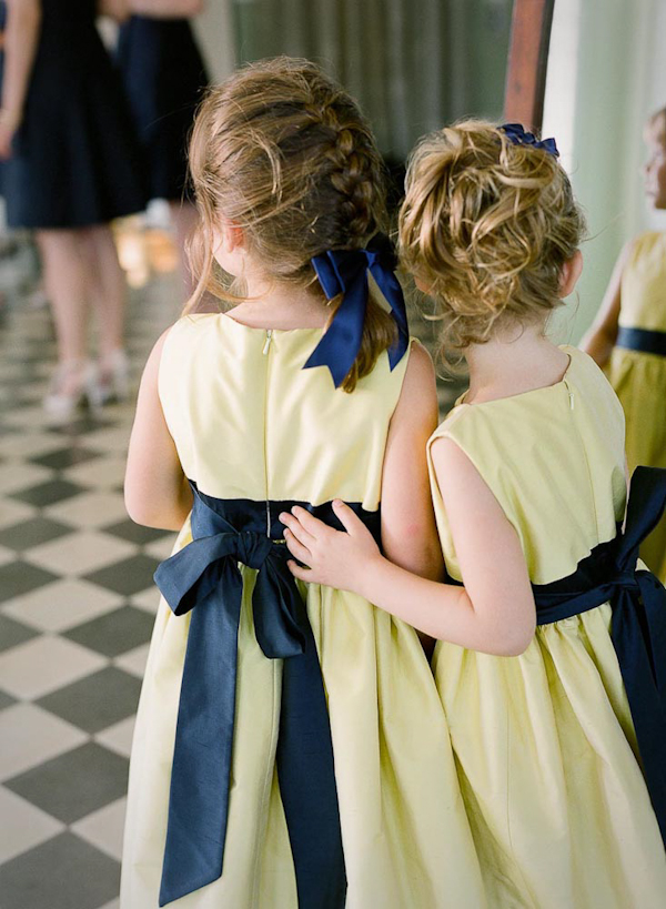 Flowergirl dresses in darling yellow with dark blue ribbon - wedding photo by top Austin based wedding photographers Q Weddings